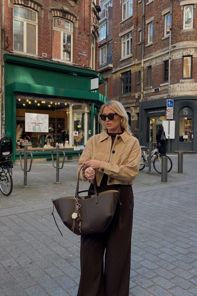 Beige Cropped Jacket + Burgundy Top + Brown Wide-Leg Pants + Black Structured Tote