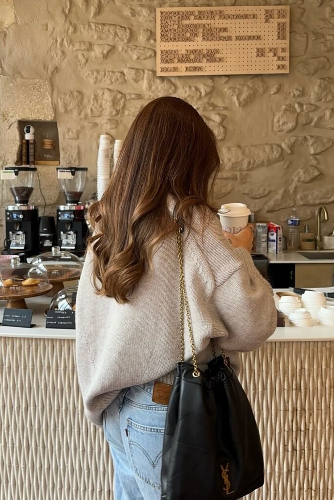 Beige Knit Sweater + Light Wash Jeans + Black YSL Drawstring Bag