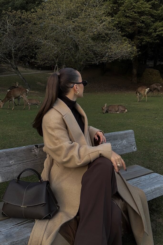 Beige Long Coat + Dark Brown Turtleneck + Brown Wide-Leg Trousers + Black Structured Bag
