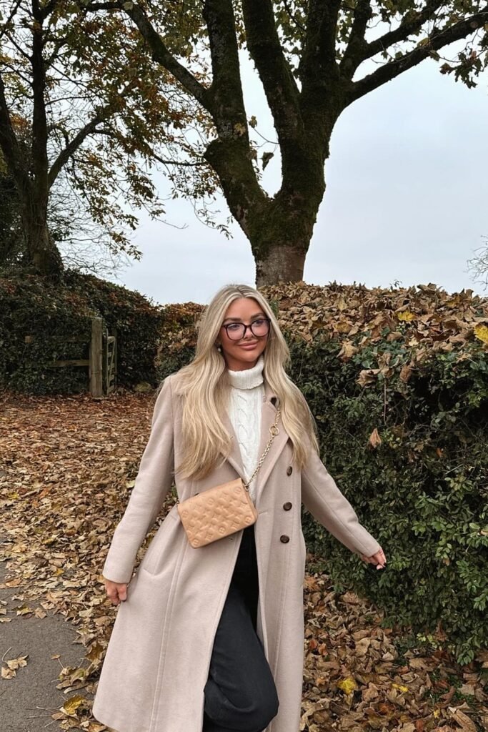 Beige Long Coat + White Cable Knit Sweater + Black Trousers + Nude Quilted Crossbody Bag + Black Glasses