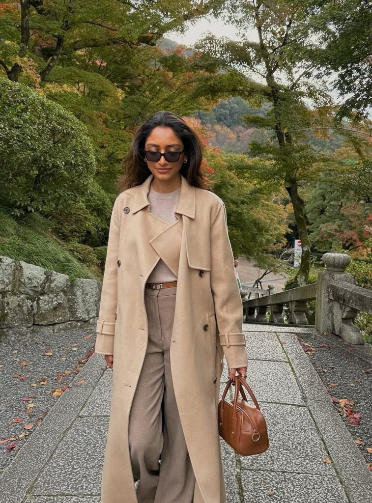 Beige Long Trench Coat + Light Taupe Knit Sweater + Taupe Wide-Leg Trousers + Brown Structured Handbag