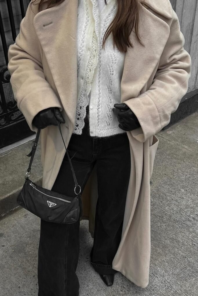 Beige Oversized Wool Coat + White Lace-Knit Cardigan + Black Flared Jeans + Pointed Black Boots + Black Mini Shoulder Bag + Leather Gloves