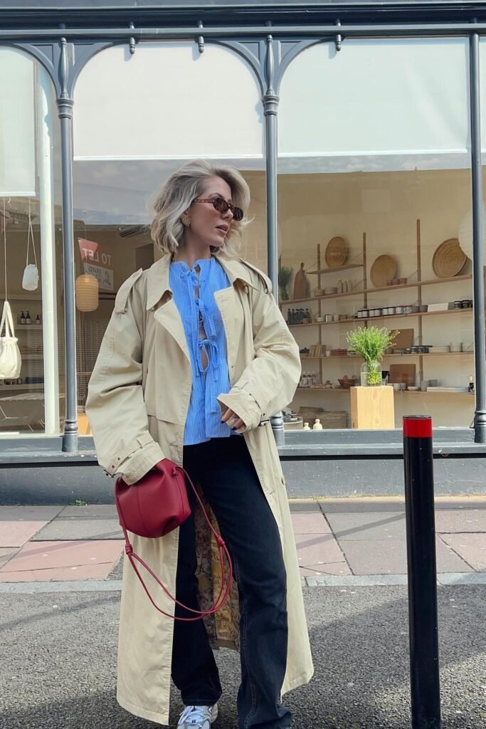 Beige Trench Coat + Blue Tie-Front Blouse + Black Jeans + Red Crossbody Bag