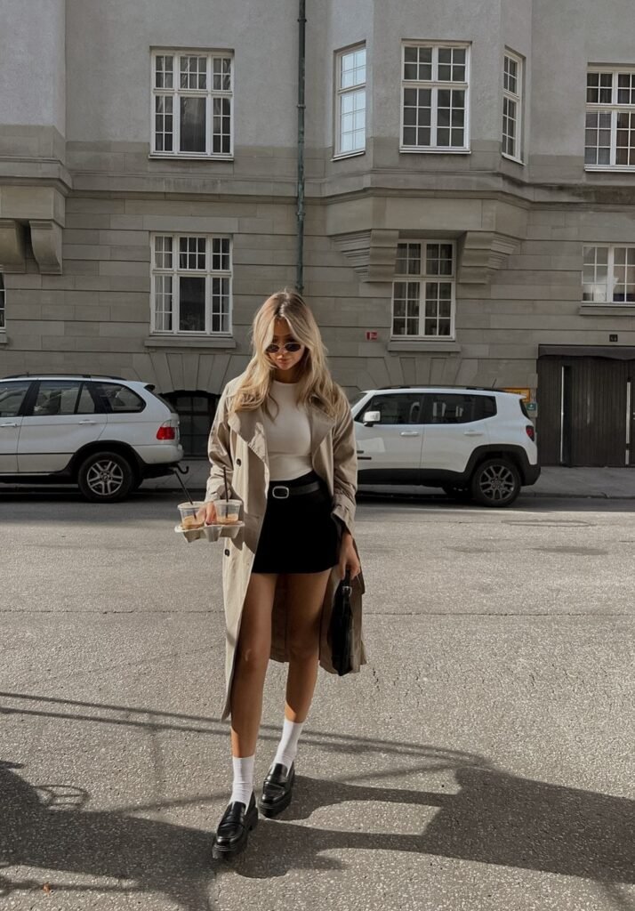 Beige Trench Coat + White Fitted Top + Black Mini Skirt + Black Loafers with White Socks + Black Structured Bag