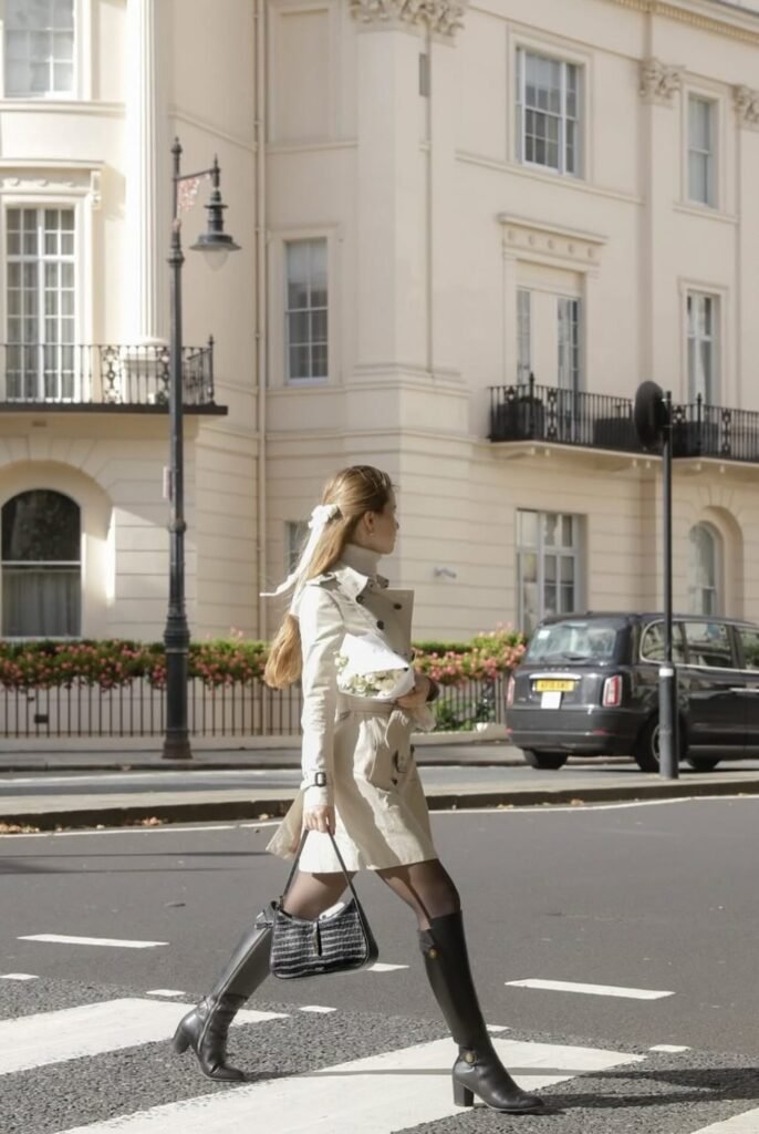 Beige Trench Dress + Sheer Black Tights + Black Knee-High Boots + Black Shoulder Bag + Ribbon Hair Tie