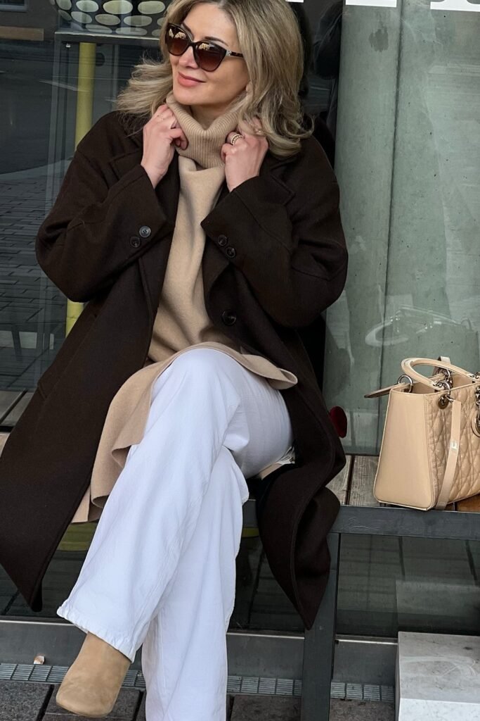 Beige Turtleneck Sweater + White Wide-Leg Pants + Long Dark Brown Coat + Beige Boots + Beige Structured Bag