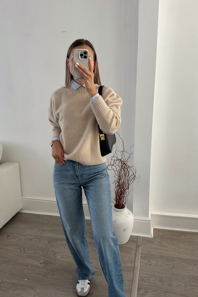 Beige V-Neck Sweater + Blue Shirt + Light Blue Straight Jeans + White Sneakers + Black Shoulder Bag
