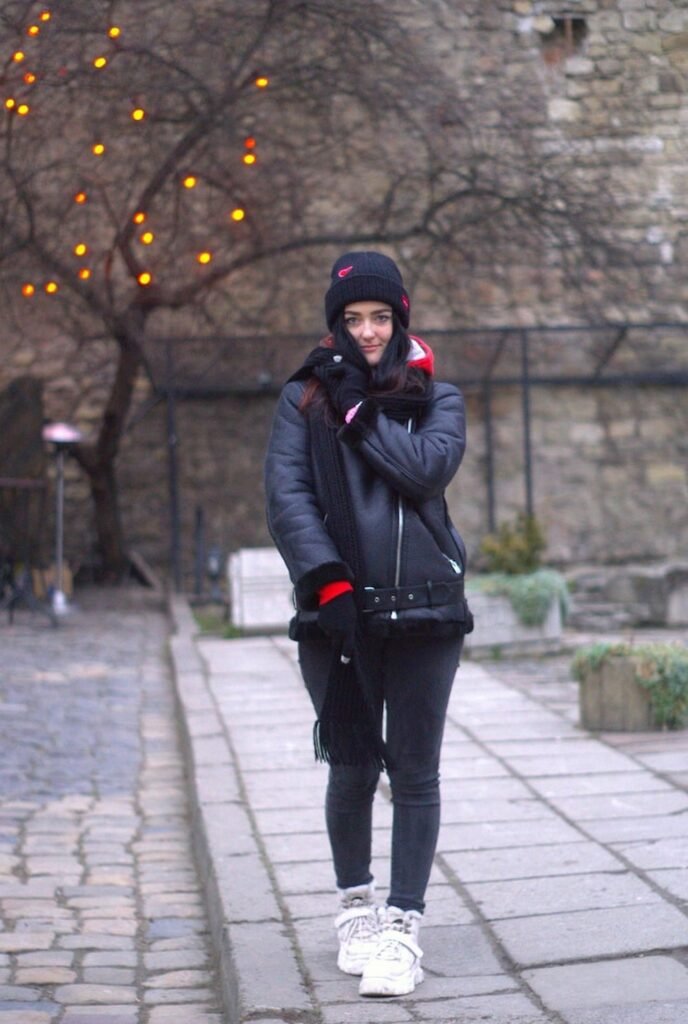 Black Beanie + Grey Shearling Jacket + Red Hoodie + Black Skinny Jeans + White Sneakers + Black Scarf