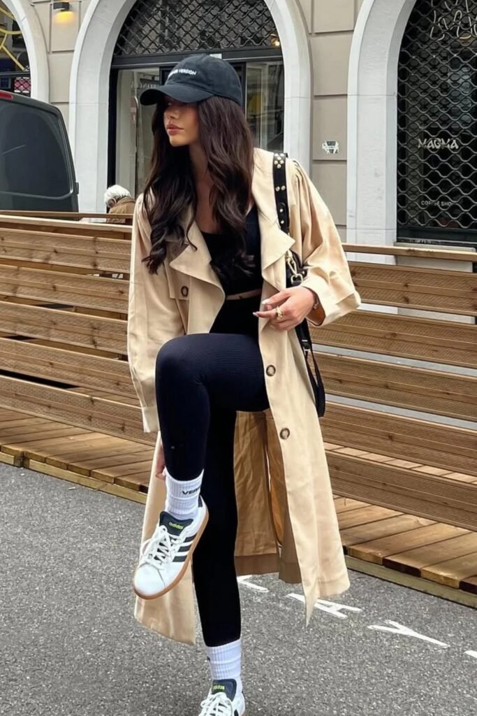 Black Crop Top + Beige Trench Coat + Black Leggings + White Sneakers + Black Cap