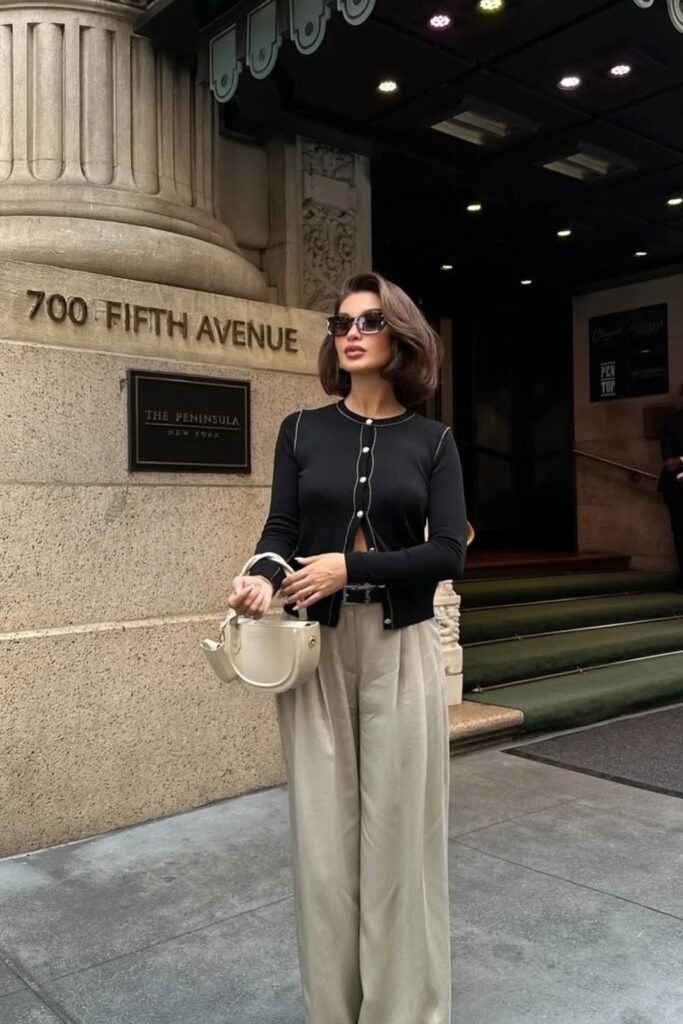 Black Cropped Cardigan with White Trim + Beige Wide-Leg Pants + Cream Half-Moon Bag + Sunglasses