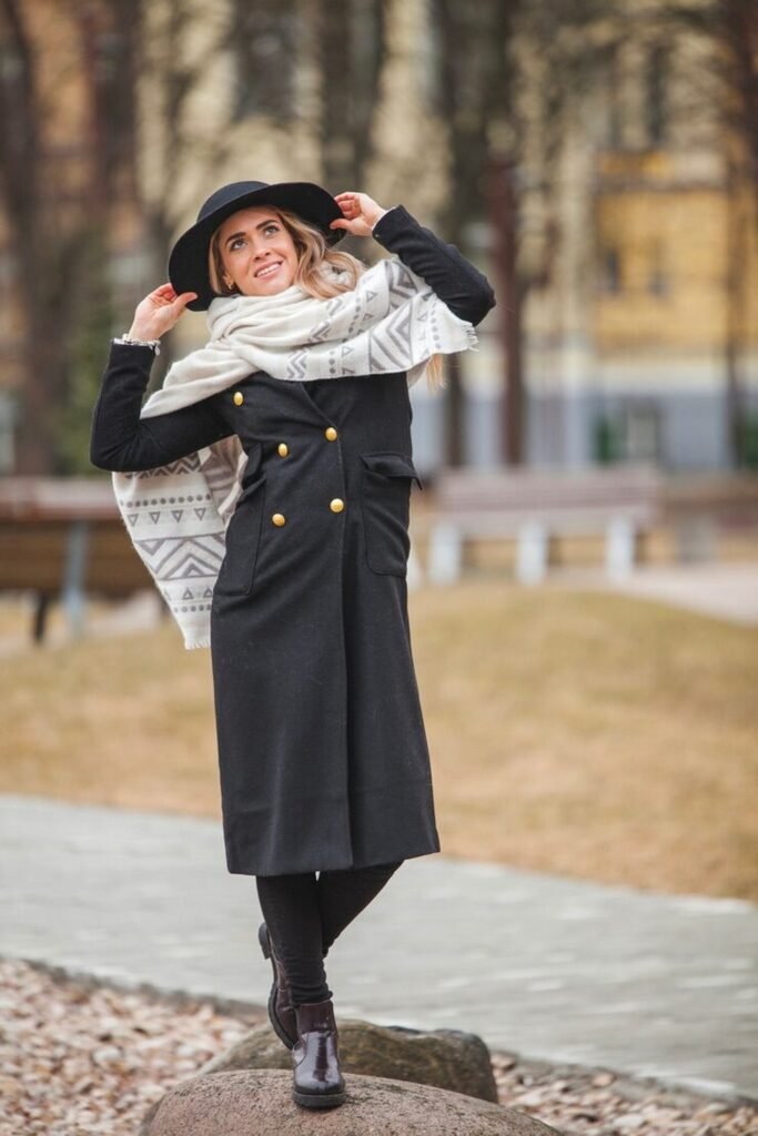 Black Double-Breasted Coat + Patterned Blanket Scarf + Wide-Brim Hat + Black Leggings + Chelsea Boots