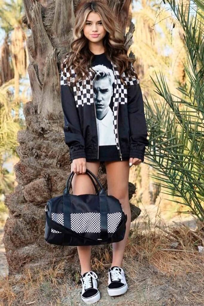 Black Graphic T-shirt + Checkerboard Bomber Jacket + Mini Skirt + Checkerboard Duffel Bag + Black Sneakers