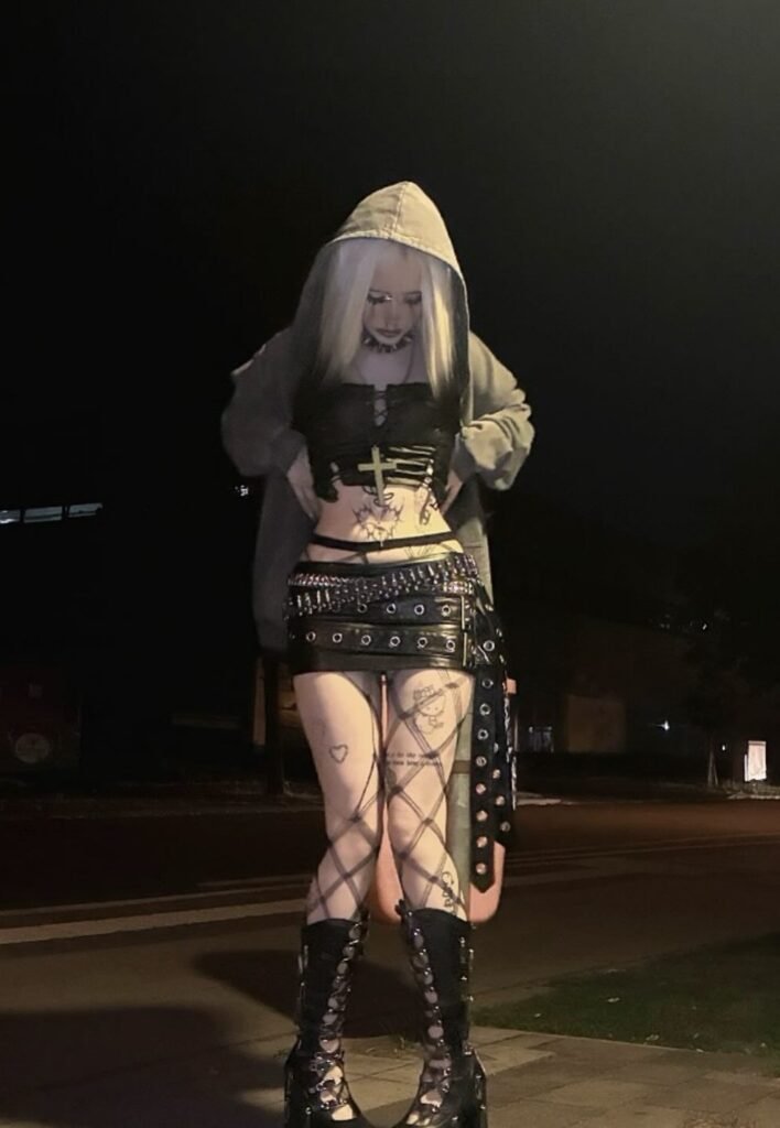 Black Lace-Up Corset Crop Top + Studded Leather Mini Skirt + Oversized Hoodie + Criss-Cross Patterned Tights + Black Platform Lace-Up Boots