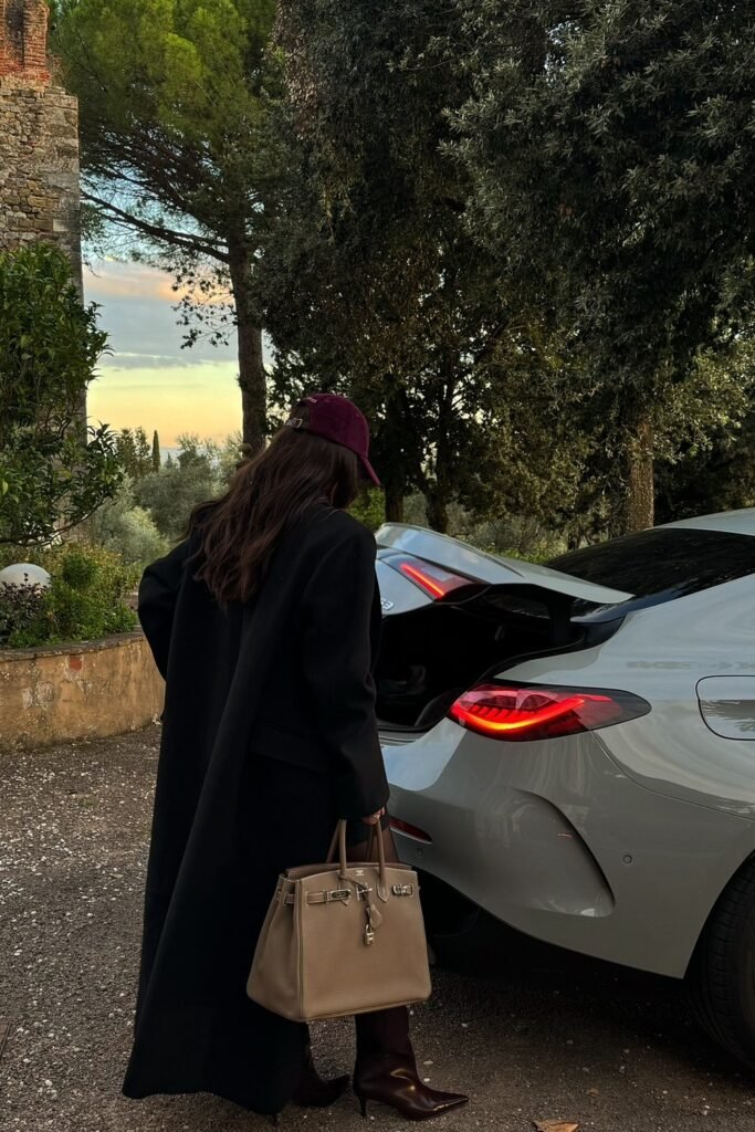 Black Long Coat + Burgundy Cap + Black Boots + Taupe Birkin Bag