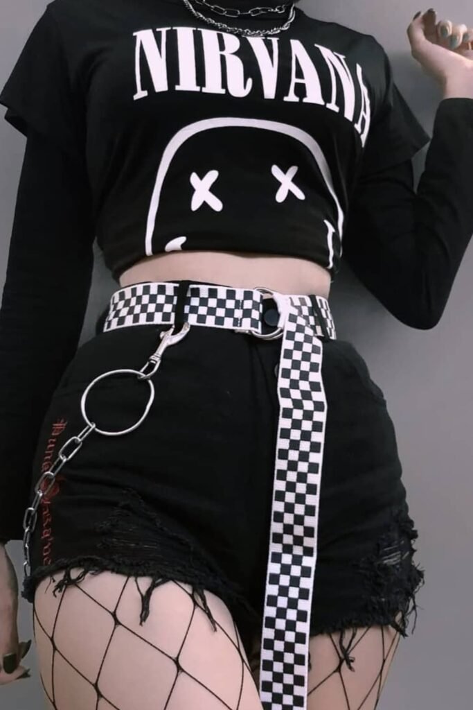 Black Nirvana Crop Top + Distressed Black Denim Shorts + Checkerboard Belt + Fishnet Tights + Silver Chains