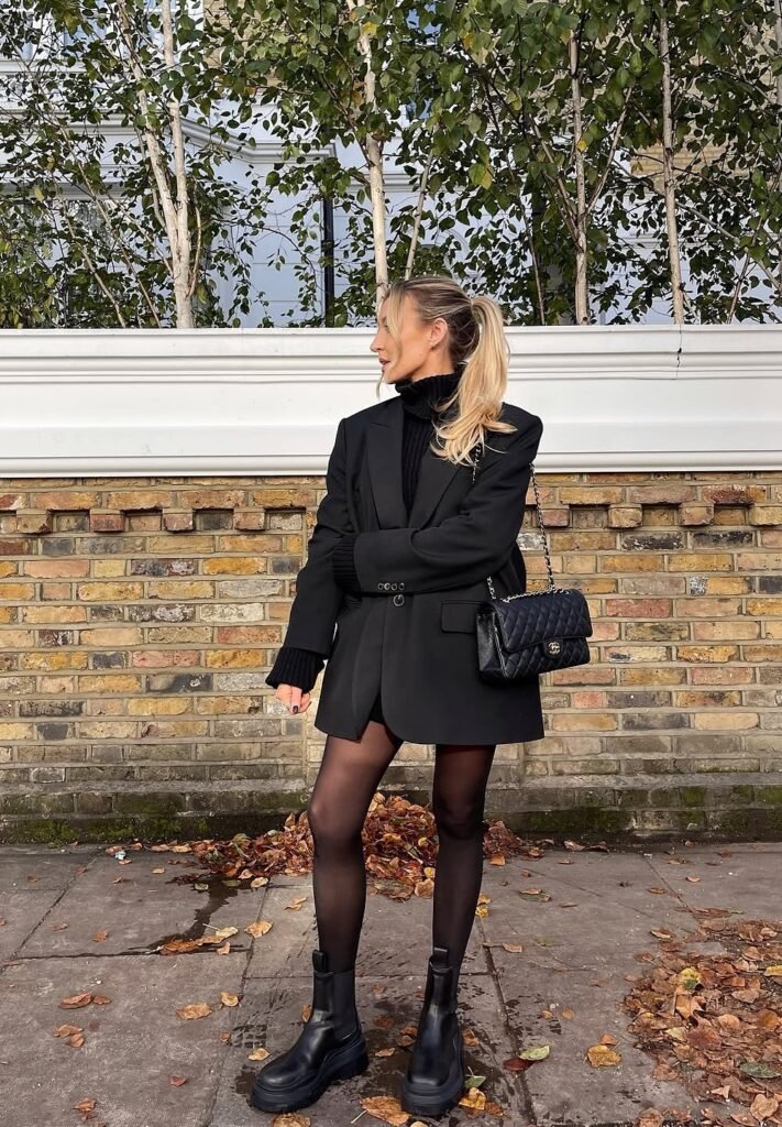 Black Oversized Blazer + Black Turtleneck Sweater + Black Mini Skirt + Black Sheer Tights + Black Quilted Chanel Bag + Black Chunky Boots