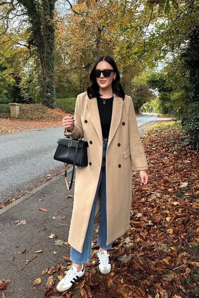 Black Top + Camel Double-Breasted Coat + Straight-Leg Blue Jeans + White Sneakers + Structured Black Bag