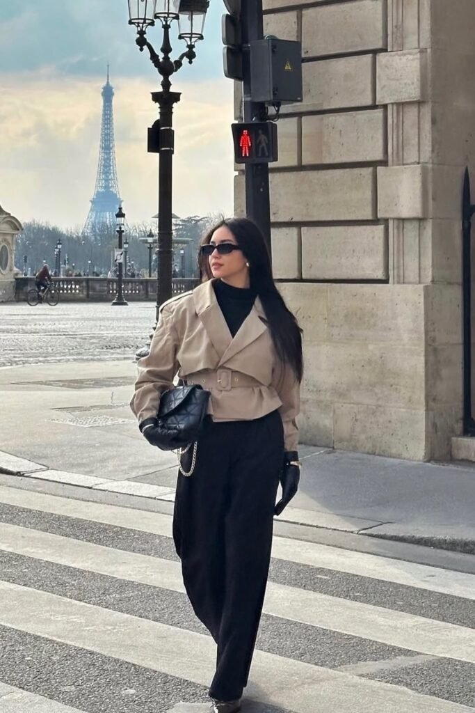Black Turtleneck + Cropped Beige Belted Jacket + Black Wide-Leg Trousers + Black Quilted Bag + Sunglasses + Gloves
