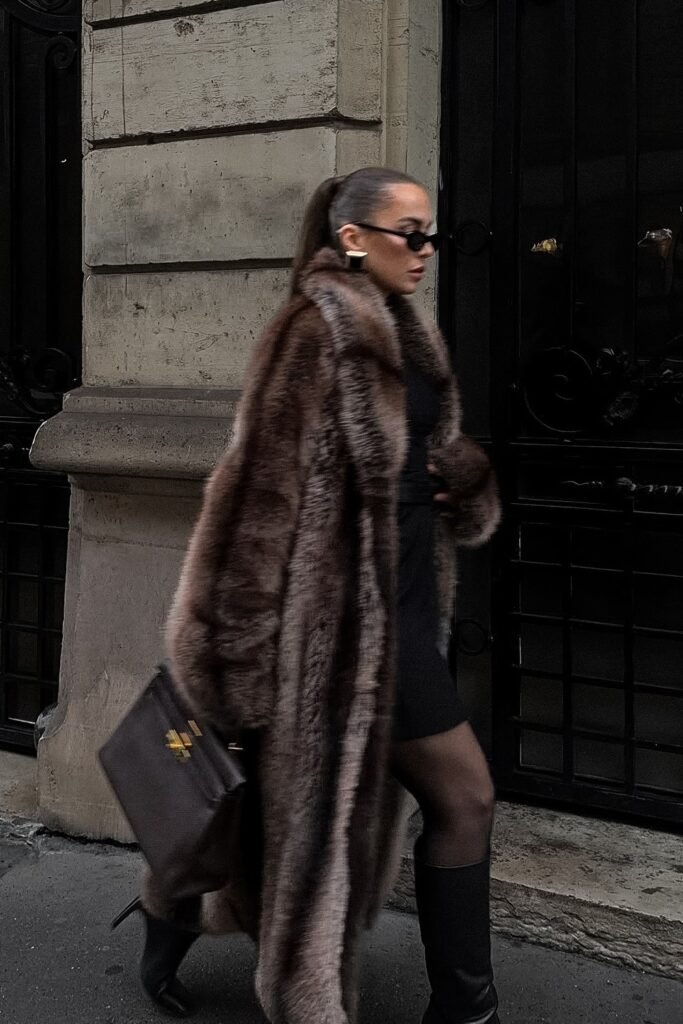 Brown Fur Coat + Black Mini Dress + Black Heeled Boots + Dark Brown Structured Bag
