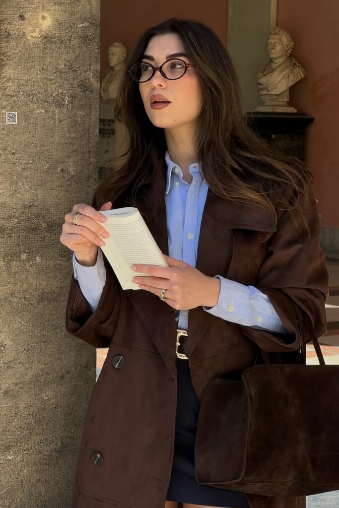 Brown Suede Trench Coat + Light Blue Button-Up Shirt + Navy Mini Skirt + Brown Suede Tote Bag + Round Glasses