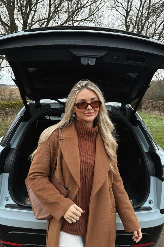 Camel Coat + Rust Brown Chunky Knit Sweater + White Pants + Brown Shoulder Bag + Brown Sunglasses