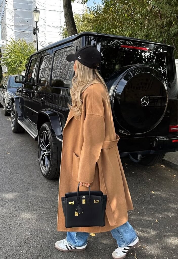 Camel Oversized Coat + Black Baseball Cap + Blue Straight-Leg Jeans + Grey Sneakers + Black Birkin Bag