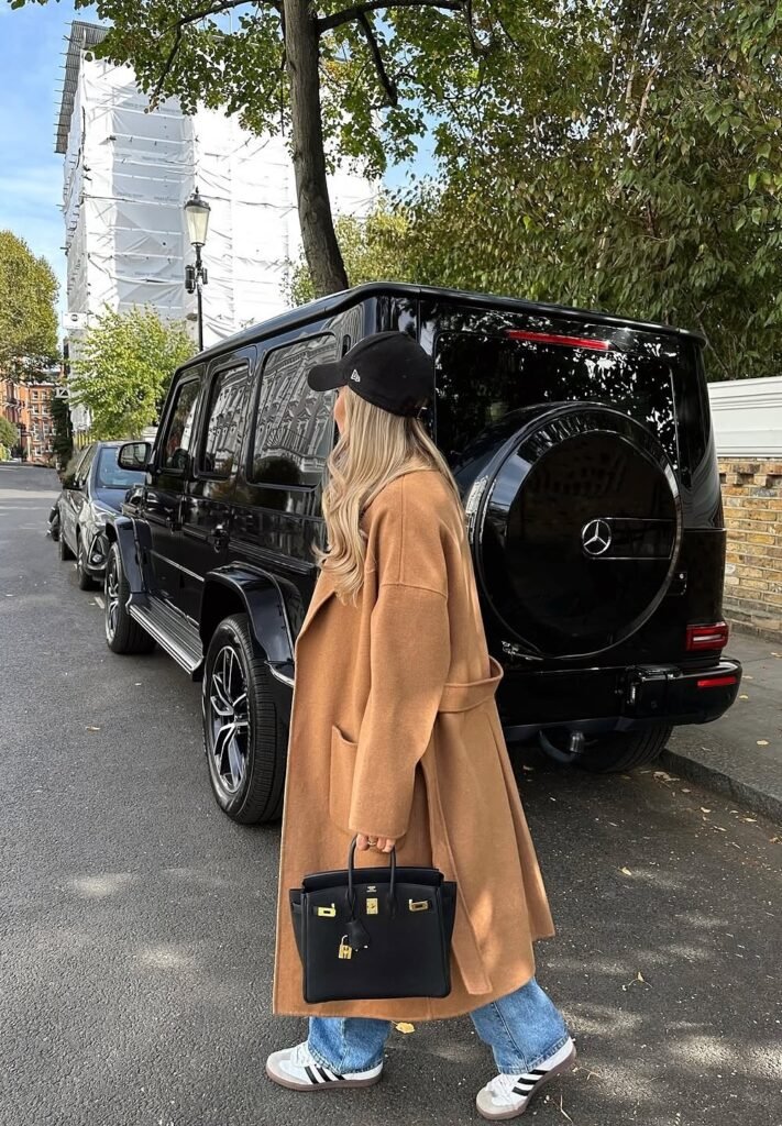 Camel Wool Coat + White Tee + Light-Wash Relaxed Jeans + Black Baseball Cap + Black Birkin Bag + Sneakers