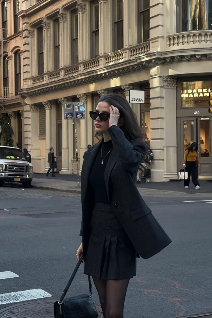 Charcoal Grey Checked Blazer + Black Turtleneck + Charcoal Grey Pleated Mini Skirt + Black Sheer Tights + Black Structured Bag