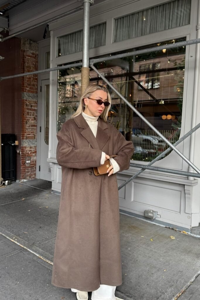 Chocolate Brown Maxi Coat + Cream Ribbed Turtleneck + White Wide-Leg Trousers + Beige Loafers + Tan Mini Wallet