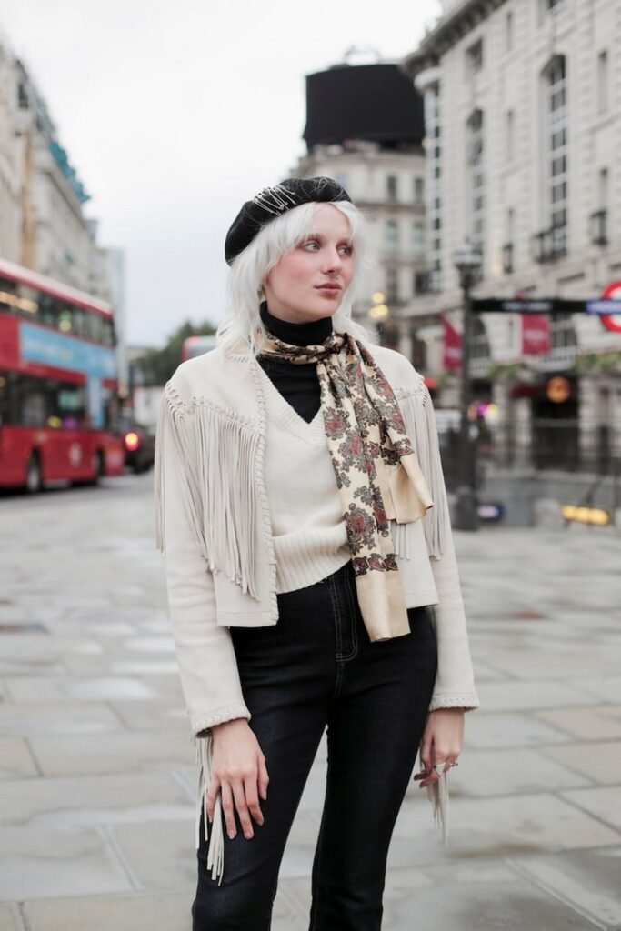 Cream Fringed Jacket + Black Turtleneck + Cream V-Neck Sweater + Black High-Waist Jeans + Paisley Scarf + Black Beret