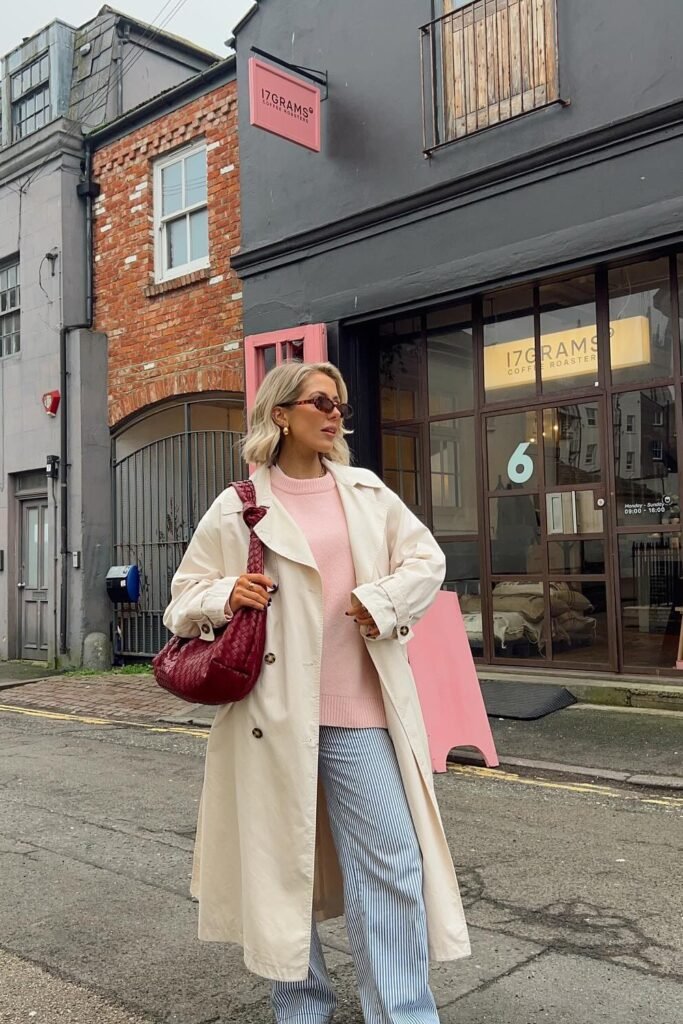 Cream Trench Coat + Pink Knit Sweater + Blue Striped Wide-Leg Pants + Red Quilted Shoulder Bag