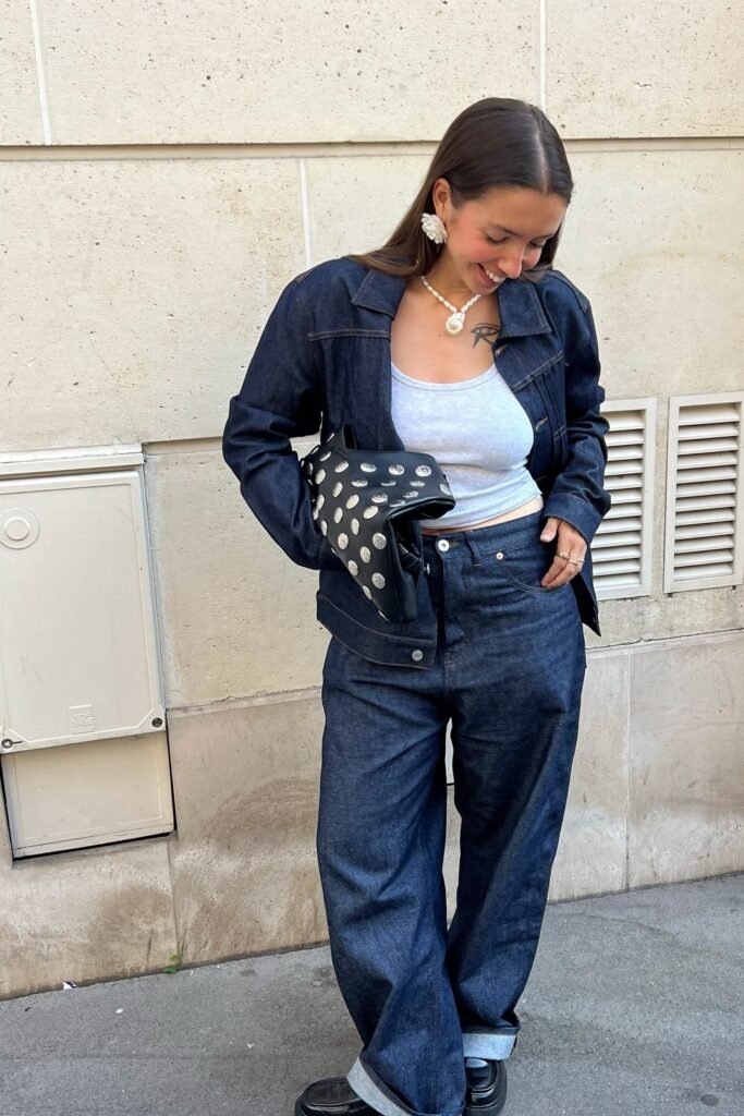 Dark Denim Jacket + White Tank Top + Dark Wide-Leg Denim Jeans + Black Loafers + Black Polka-Dot Clutch + Pearl Statement Jewelry