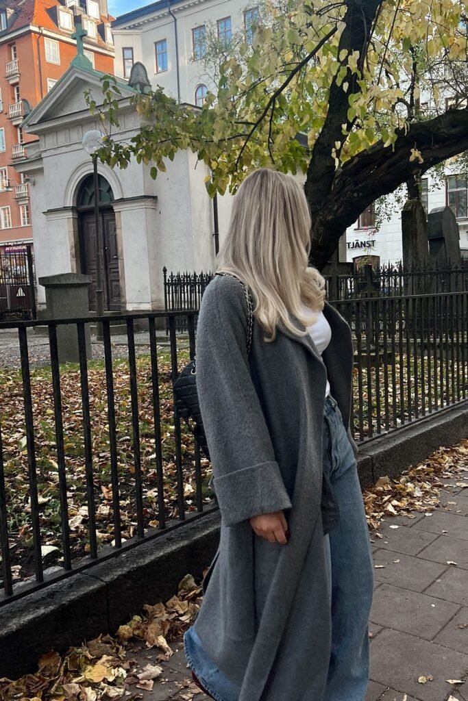 Grey Long Coat + White Top + Blue Wide-Leg Jeans + Black Quilted Shoulder Bag