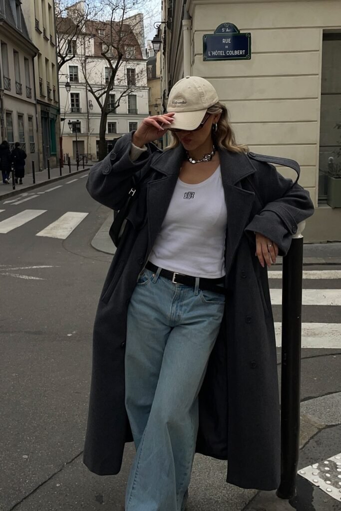 Grey Oversized Trench Coat + White Tank Top + Light Blue Wide-Leg Jeans + Beige Baseball Cap + Black Belt + Silver Chunky Necklace