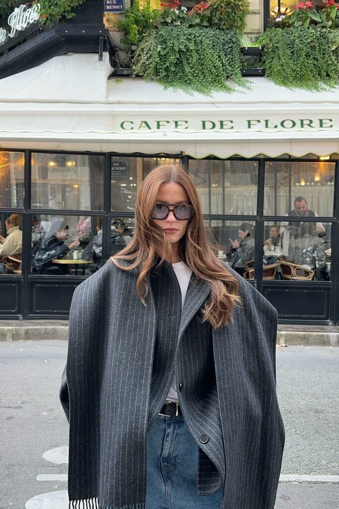 Grey Pinstripe Cape Blazer + White Tee + Blue Jeans + Black Belt + Oversized Sunglasses