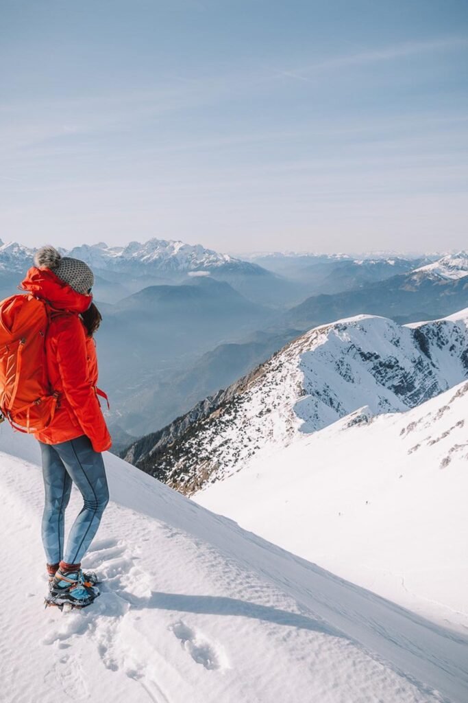 Grey Pom-Pom Beanie + Red Puffer Jacket + Blue Geometric Leggings + Hiking Boots + Orange Backpack