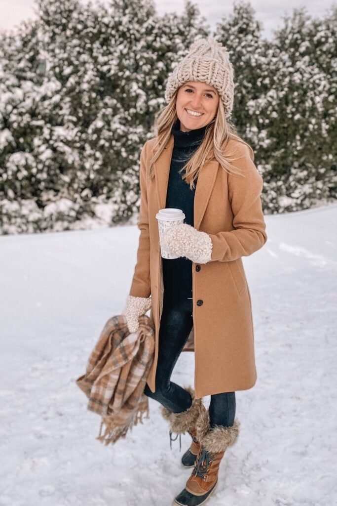 Camel Coat + Black Turtleneck + Black Leggings + Beige Knit Beanie + Fur Winter Boots + Plaid Scarf