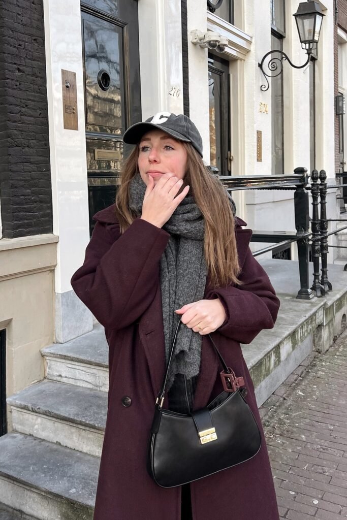 Burgundy Long Coat + Grey Sweater + Grey Knit Scarf + Black Baseball Cap + Black Shoulder Bag