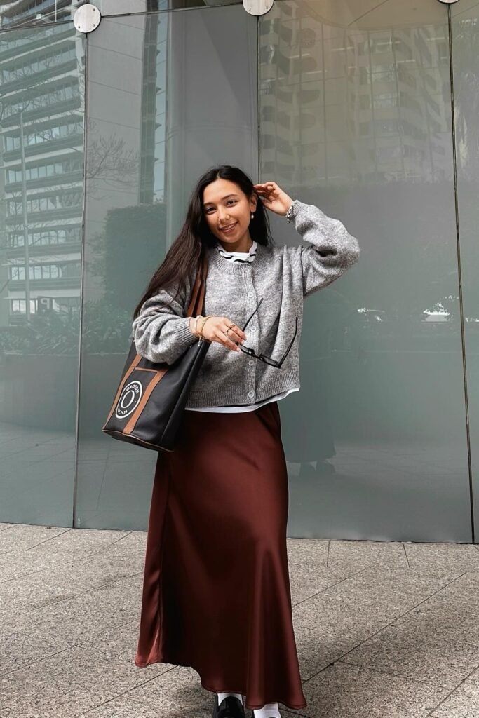 Grey Cardigan + White Shirt with Black-Striped Collar + Brown Satin Maxi Skirt + Black Tote Bag + Black Shoes