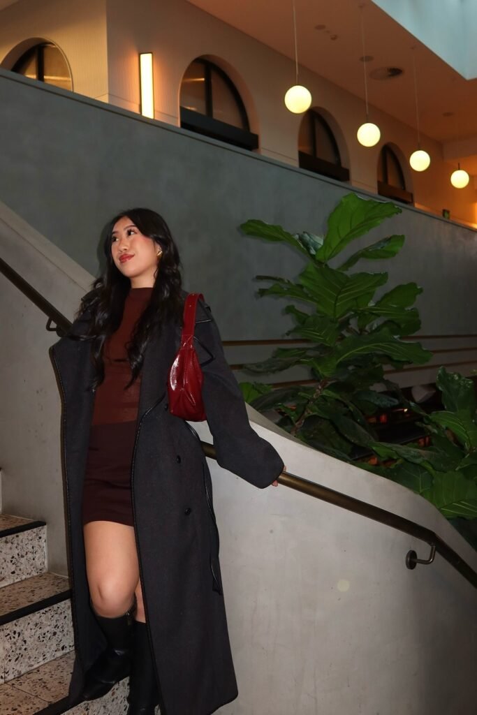 Dark Grey Long Coat + Brown Top + Brown Mini Skirt + Black Knee-High Boots + Red Shoulder Bag