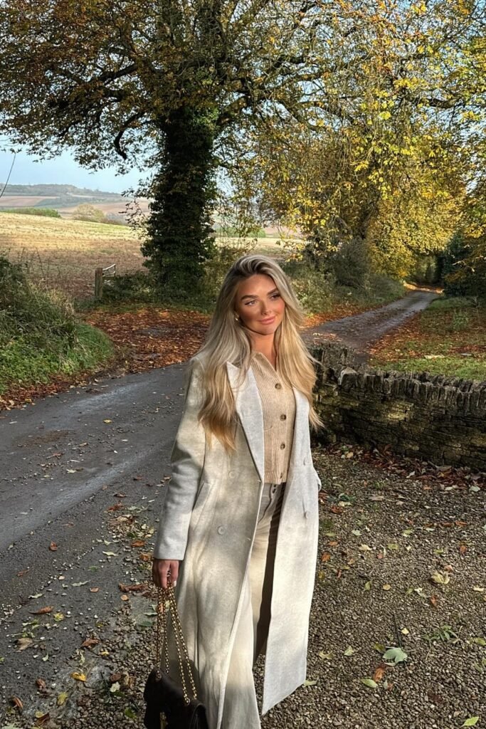 Light Grey Long Coat + Beige Button-Up Cardigan + Beige Trousers + Black Handbag with Gold Chain