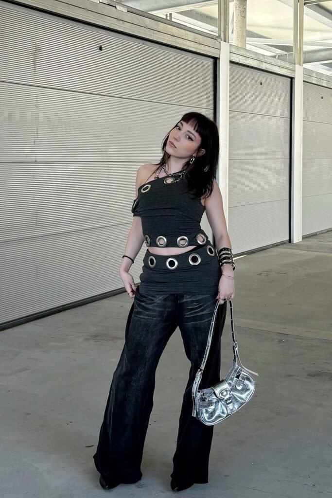 One-Shoulder Black Grommet Strap Top + Black Wide-Leg Pants + Silver Metallic Shoulder Bag