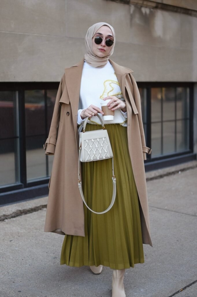Tan Trench Coat + White Graphic Sweater + Olive Green Pleated Skirt + Cream Boots