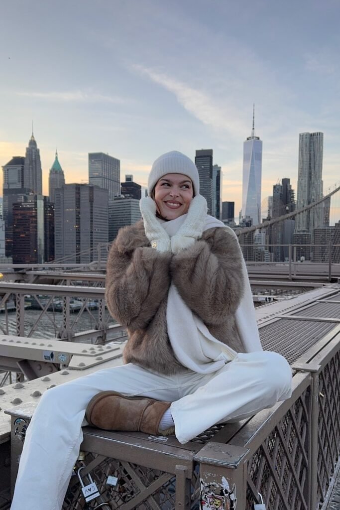 Taupe Faux-Fur Jacket + White Beanie + White Scarf + White Wide-Leg Pants + Chestnut Shearling Slippers + Knit Mittens