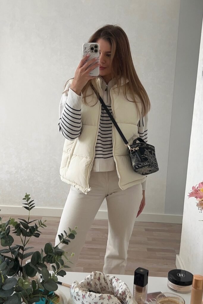 White Puffer Vest + Striped Knit Sweater + Cream Jeans + Small Printed Crossbody Bag