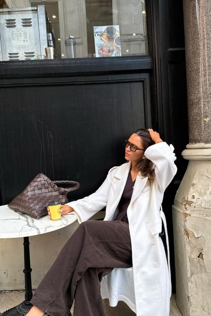 White Wool Coat + Black Top + Brown Wide-Leg Trousers + Oversized Woven Tote Bag
