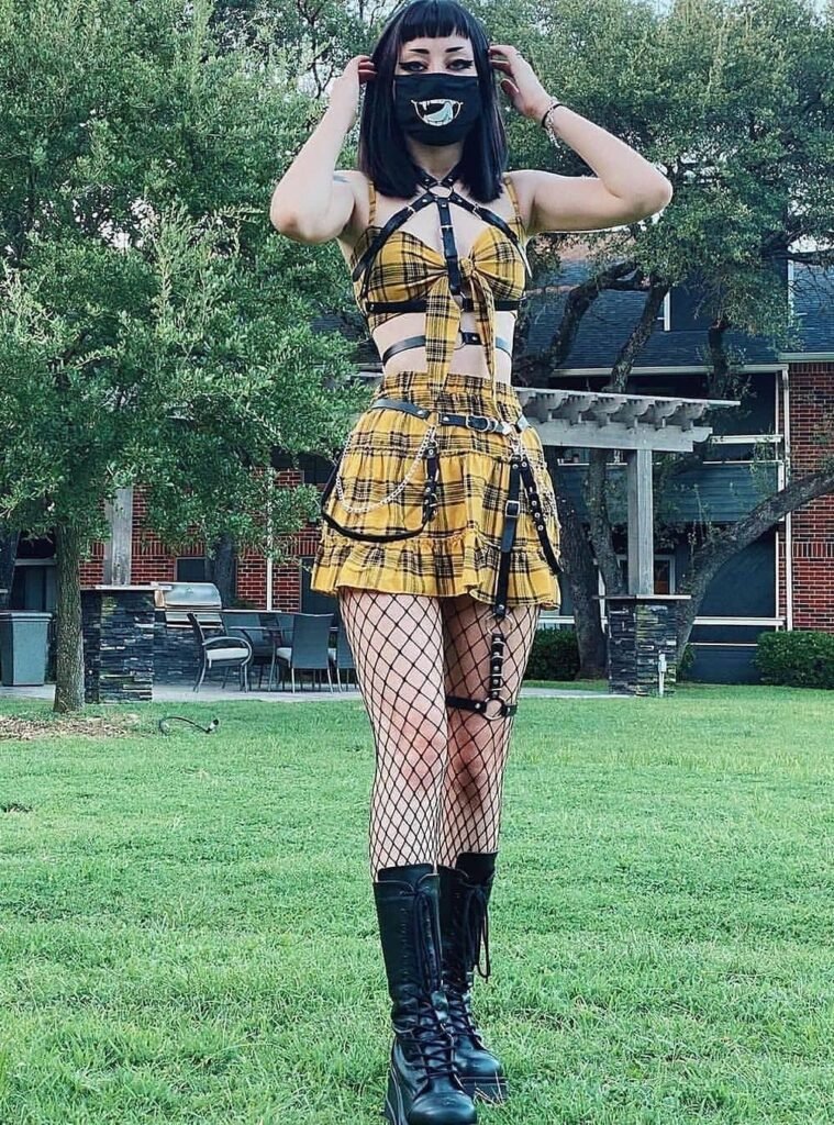 Yellow Plaid Strappy Crop Top + Matching Plaid Pleated Skirt + Fishnet Tights + Black Harness Belt + Black Lace-Up Combat Boots