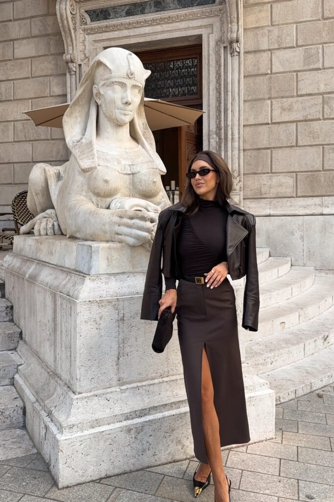 Black Cropped Leather Jacket + Black Ruched Turtleneck Top + Brown High-Slit Midi Skirt