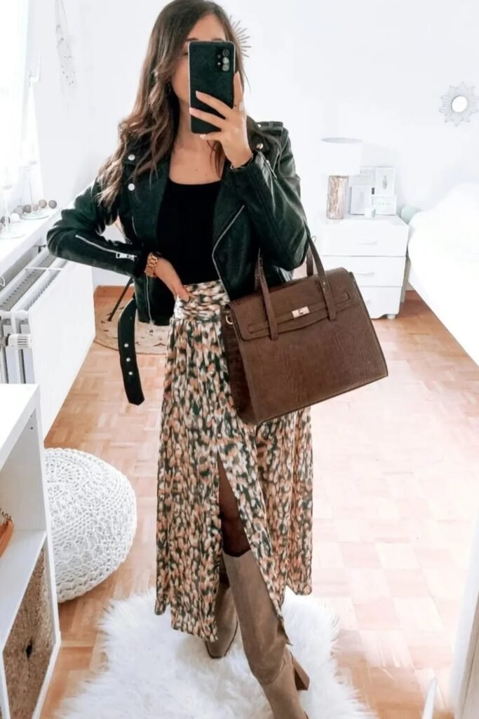 Black Leather Jacket + Black Top + Green/Orange Floral Maxi Skirt with Slit + Taupe Knee-High Boots + Brown Croc-Effect Tote Bag