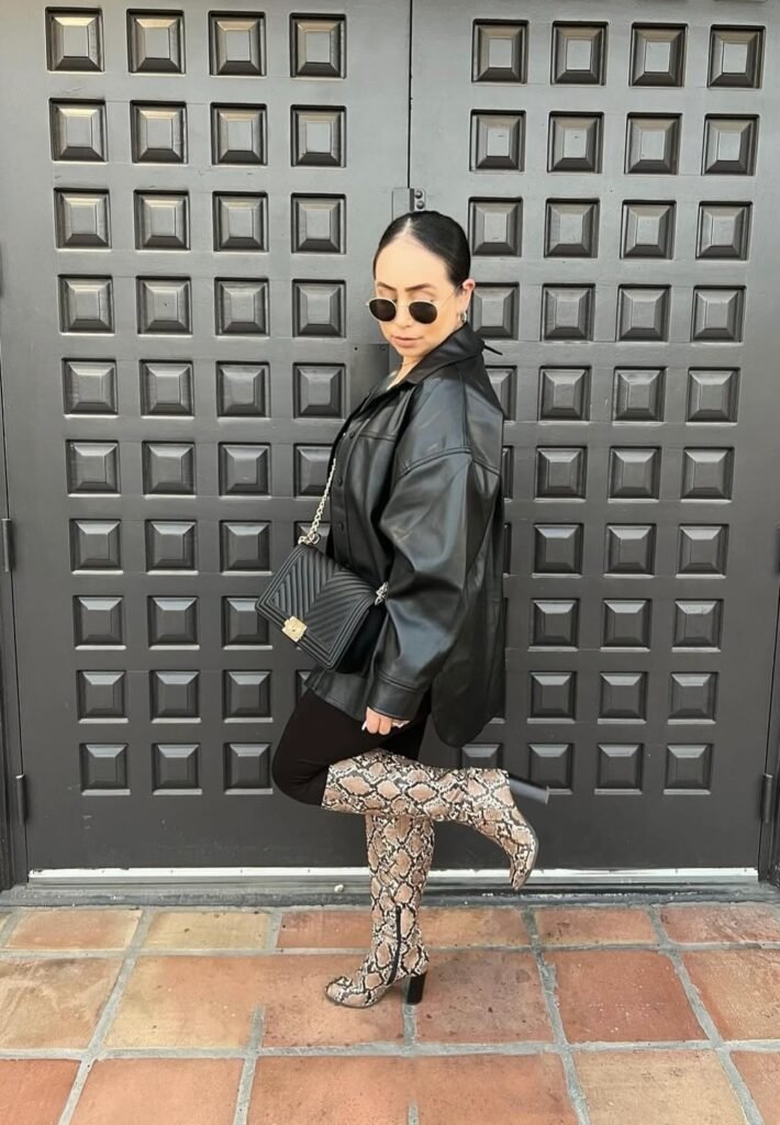 Black Leather Overshirt + Black Leggings + Snakeskin Knee-High Boots + Black Quilted Shoulder Bag + Round Sunglasses